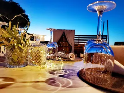 a table with wine glasses on a table at Eco Beach And Magic Garden Hotel in Gennadi