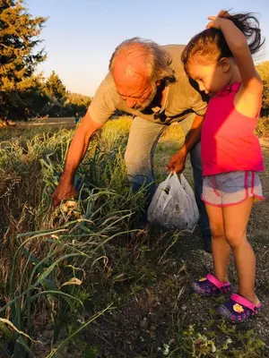 an older woman and a little girl standing in a field at Eco Beach And Magic Garden Hotel in Gennadi