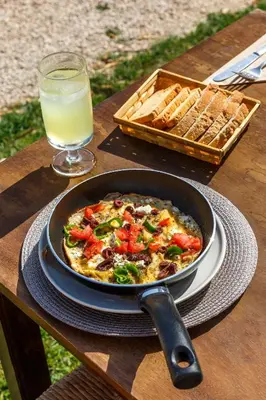 a pan of pizza on a table with a glass of milk at Eco Beach And Magic Garden Hotel in Gennadi