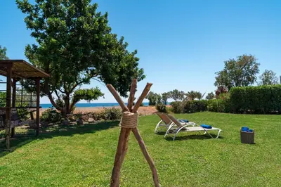 a wooden stick in the grass next to a chair at Eco Beach And Magic Garden Hotel in Gennadi
