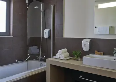 a bathroom with a shower and a sink and a tub at Atlantica Plimmiri in Plimmiri