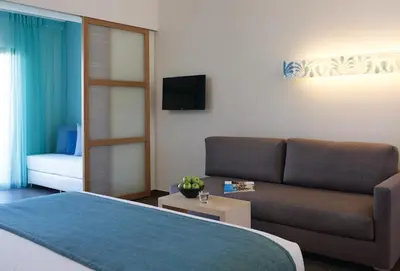 a living room with a couch and a television at Atlantica Plimmiri in Plimmiri