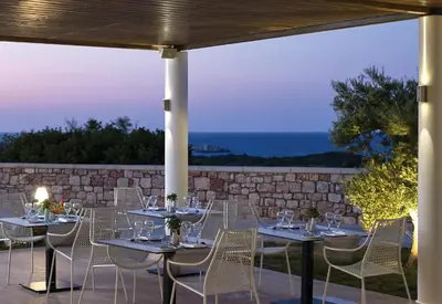 a group of tables and chairs on a patio at Atlantica Plimmiri in Plimmiri