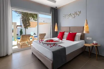a bedroom with a large bed with red pillows at Belmare Hotel in Lardos
