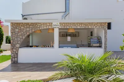 a bar in a building with a stone wall at Belmare Hotel in Lardos