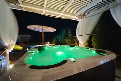 a swimming pool at night with an umbrella at Heliophos Villa Amalthia in Kiotari