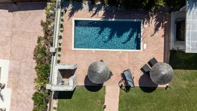 an overhead view of a swimming pool with umbrellas at Heliophos Villa Amalthia in Kiotari