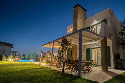 a villa with a view of the backyard at night at Heliophos Villa Amalthia in Kiotari