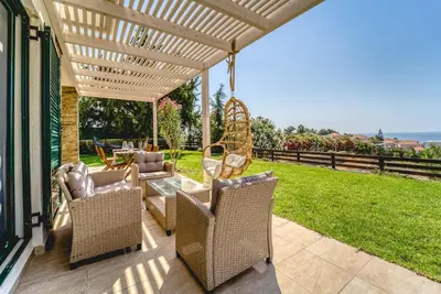 a patio with wicker chairs and a table at Heliophos Villa Amalthia in Kiotari