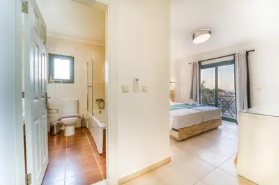 a bedroom with a bed and a bathroom at Heliophos Villa Amalthia in Kiotari