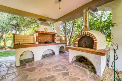 a patio with an outdoor oven in a yard at Heliophos Villa Aitheria in Kiotari