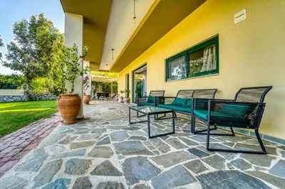 a patio with benches on a stone patio at Heliophos Villa Aitheria in Kiotari