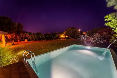 a swimming pool in a yard at night at Heliophos Villa Aitheria in Kiotari