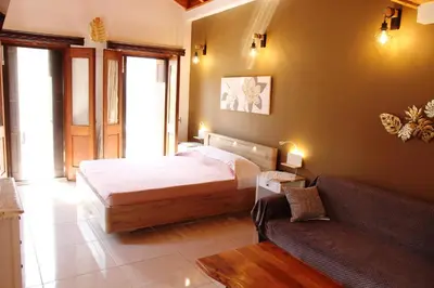 a bedroom with a bed and a couch at Main square apartment in Symi
