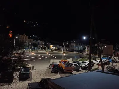 a parking lot at night with cars parked at Main square apartment in Symi