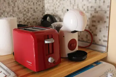 a red and white toaster sitting on top of a counter at Main square apartment in Symi
