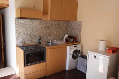 a kitchen with a sink and a washing machine at Main square apartment in Symi