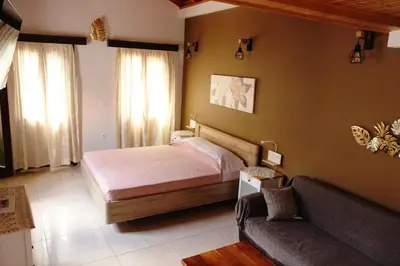 a bedroom with a bed and a couch at Main square apartment in Symi