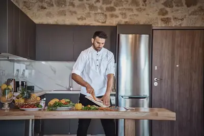 a man standing in a kitchen preparing food at Luxury Rhodes Villa Amel Villa Sea View Private Swimming Pool in Rhodes Town