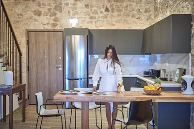 a woman standing at a table in a kitchen at Luxury Rhodes Villa Amina Villa Sea View Private Swimming Pool in Rhodes Town