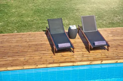 two chairs sitting on a wooden deck next to a swimming pool at Luxury Rhodes Villa Amina Villa Sea View Private Swimming Pool in Rhodes Town