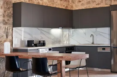 a kitchen with a wooden table and black cabinets at Luxury Rhodes Villa Anissa Villa Sea View Private Swimming Pool in Rhodes Town