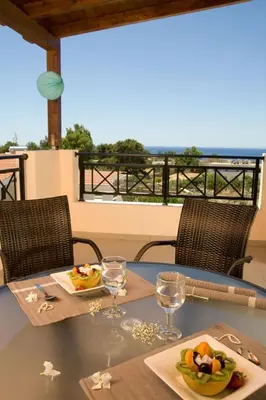 a table with two plates of food and a view of the ocean at Executive Rhodes Villa 4 Bedroom 4 Bathroom Bd Villa Pefkos in Pefki Rhodes