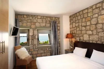 a bedroom with a bed and a stone wall at Executive Rhodes Villa Villa Althea 2 Bedroom Villa With Sea Views Pefkos in Pefki Rhodes