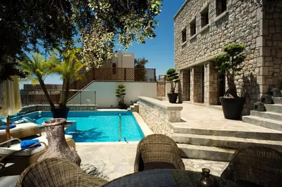 a swimming pool next to a building with a house at Executive Rhodes Villa Villa Althea 2 Bedroom Villa With Sea Views Pefkos in Pefki Rhodes