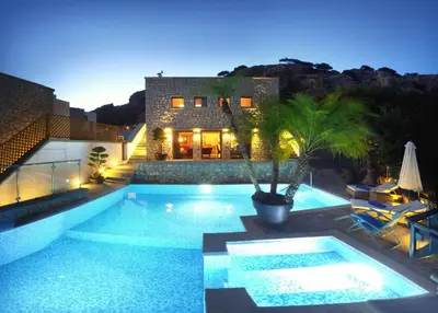 a swimming pool in front of a house at night at Executive Rhodes Villa Villa Althea 2 Bedroom Villa With Sea Views Pefkos in Pefki Rhodes