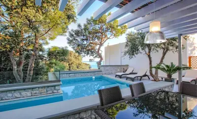 an indoor pool with chairs and a patio with a view at Executive Rhodes Villa Villa Barbie 2 Bedroom With Sea Views Pefkos in Pefki Rhodes