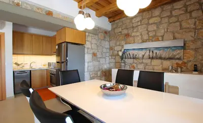 a kitchen with a table with a bowl of fruit on it at Executive Rhodes Villa Villa Barbie 2 Bedroom With Sea Views Pefkos in Pefki Rhodes