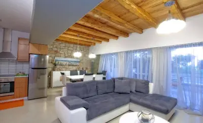 a living room with a couch and a kitchen at Executive Rhodes Villa Villa Barbie 2 Bedroom With Sea Views Pefkos in Pefki Rhodes