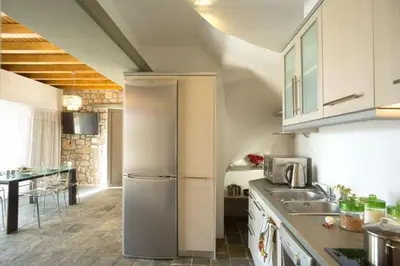 a kitchen with a refrigerator and a table in it at Executive Rhodes Villa Villa Ellie 2 Bedroom Villa With Sea Views Pefkos in Pefki Rhodes