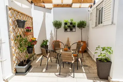 a patio with a table and chairs and potted plants at Gitonia Residence - Islander's Home Collection in Rhodes Town