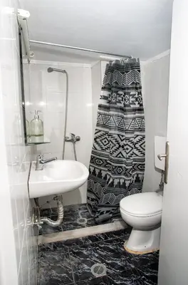 a bathroom with a sink and a toilet and a shower curtain at Gitonia Residence - Islander's Home Collection in Rhodes Town