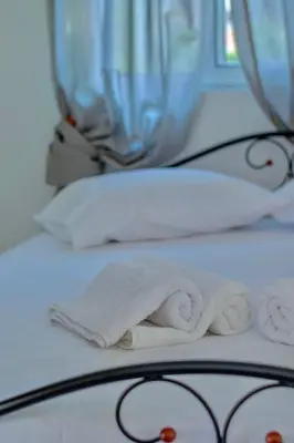 a white bed with two towels and a mirror at Gitonia Residence - Islander's Home Collection in Rhodes Town