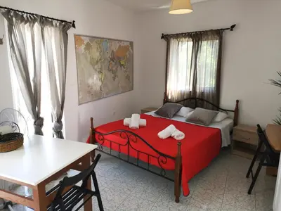 a bedroom with a red bed and a table at Gitonia Residence - Islander's Home Collection in Rhodes Town