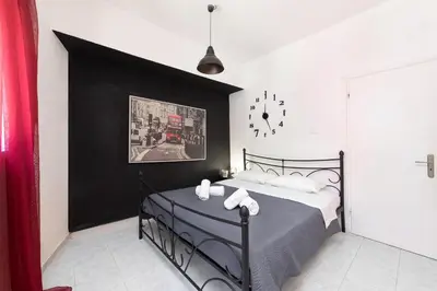 a bedroom with a bed with a black wall at Gitonia Residence - Islander's Home Collection in Rhodes Town