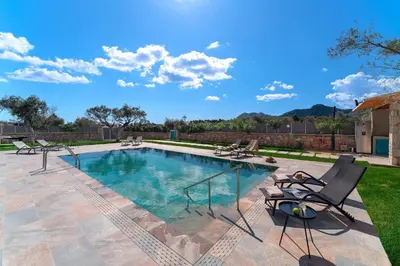 a swimming pool with lounge chairs in a yard at Serenity Villas in Kolimbia