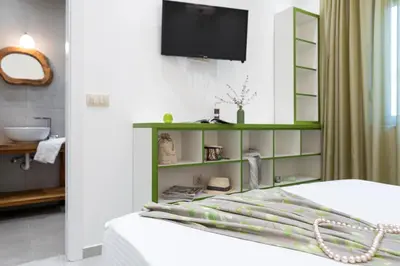 a room with a bed with a green shelf at Serenity Villas in Kolimbia