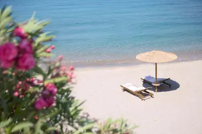 a beach with two lounge chairs and an umbrella at Ella Elissa - Adults Only in Kallithea Rhodes