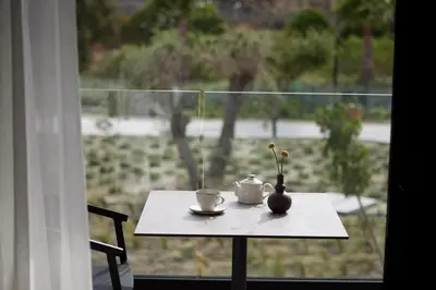 a table with a coffee cup and a vase on a window at Ella Helea in Kallithea Rhodes