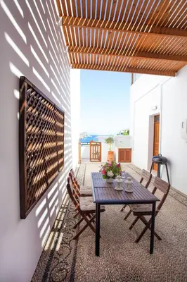 a dining room with a table and two chairs at Villa Thalassa Suites 3 Modern Comfort Traditional Greek Charm in Líndos