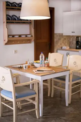 a dining room table with chairs and a light fixture at Villa Thalassa Suites 3 Modern Comfort Traditional Greek Charm in Líndos