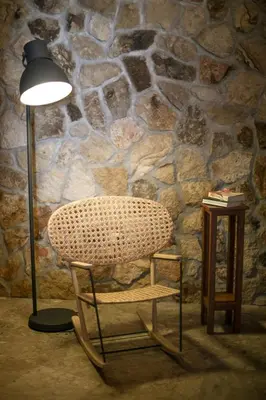 a lamp and a chair next to a stone wall at Villa Thalassa Suites 3 Modern Comfort Traditional Greek Charm in Líndos