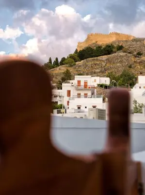 a person looking out of a window at a city at Villa Thalassa Suites 3 Modern Comfort Traditional Greek Charm in Líndos