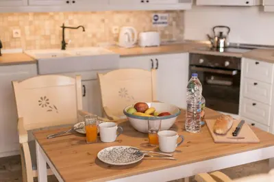 a kitchen with a wooden table with a bowl of fruit at Villa Thalassa Suites 3 Modern Comfort Traditional Greek Charm in Líndos