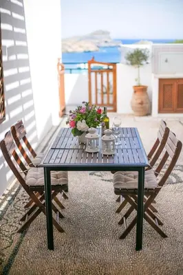 a blue table with two chairs and flowers on it at Villa Thalassa Suites 3 Modern Comfort Traditional Greek Charm in Líndos