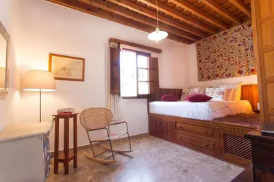 a bedroom with a bed and a table and a chair at Villa Thalassa Suites 3 Modern Comfort Traditional Greek Charm in Líndos